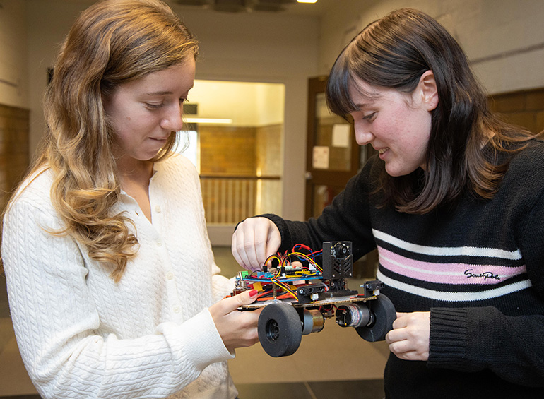 Two students look at their electrical engineering project