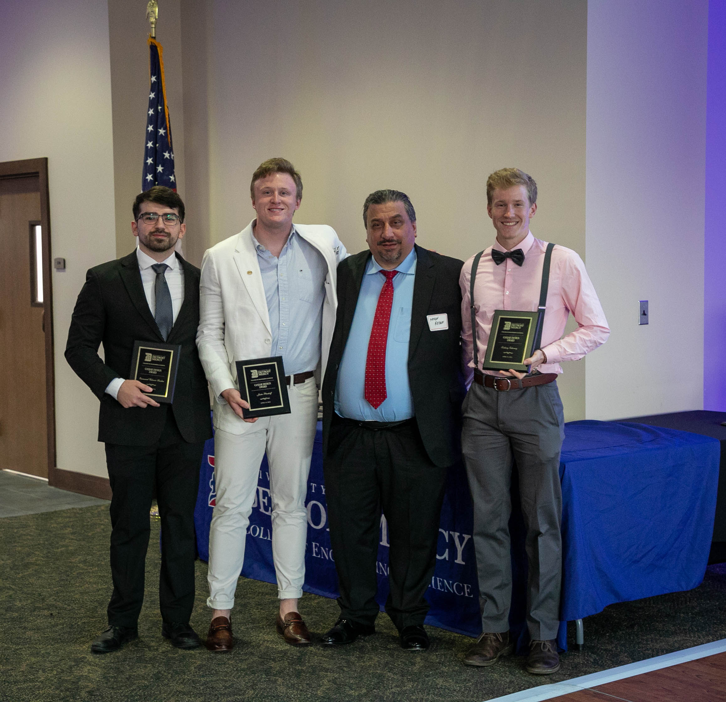 four men holding award plaques