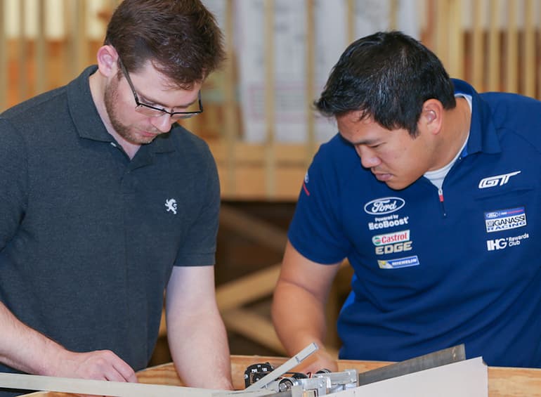 two male students building something out of sight