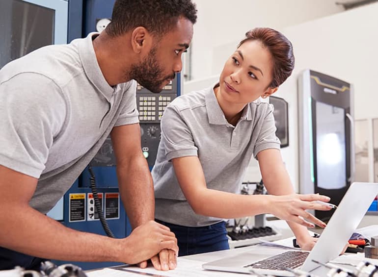 Adult male and female technical workers conferring.