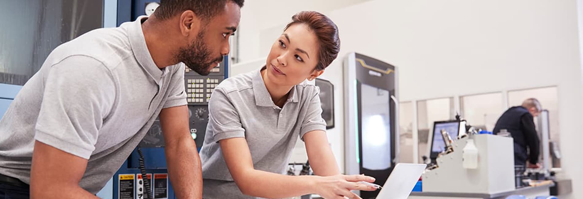 engineering manager showing employee something unseen on a laptop