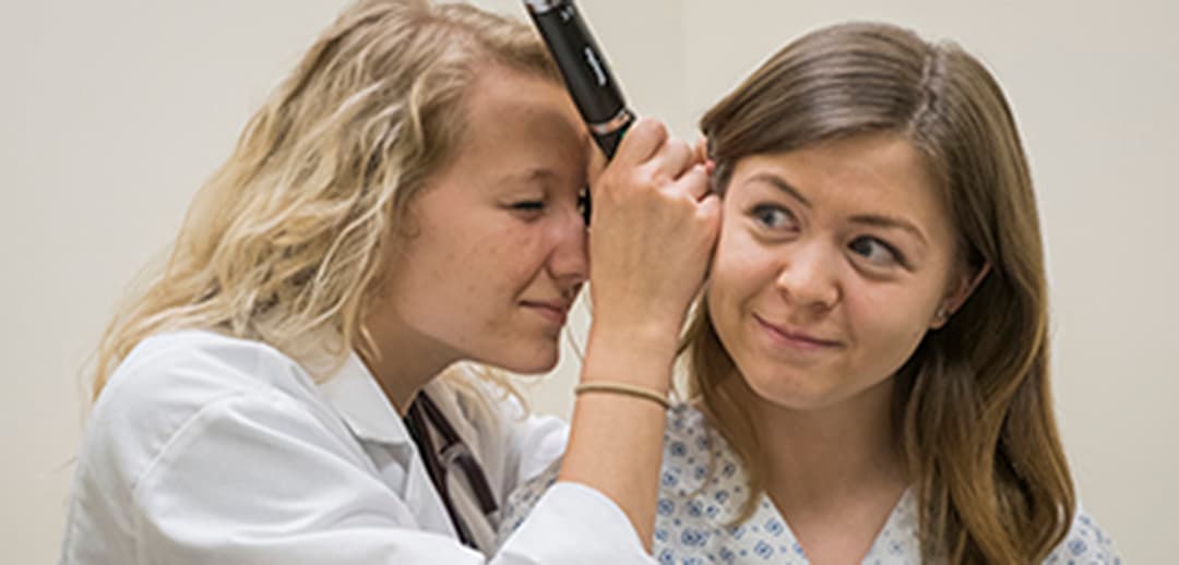 PA student checking a patient's ear