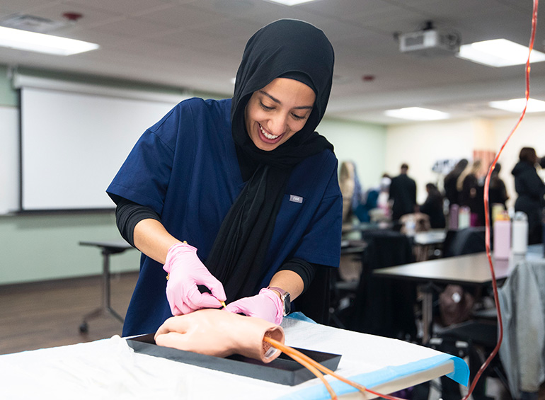 A PA student practices using IVs