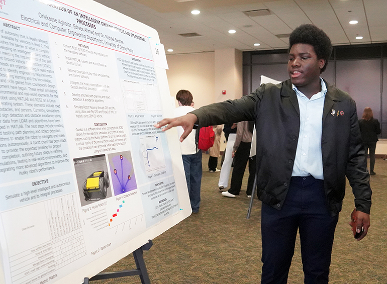 student explaining research poster