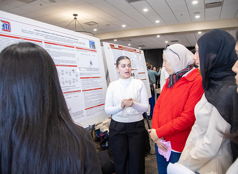 student giving poster presentation